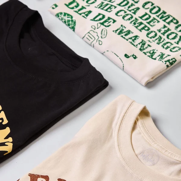 Camiseta colombiana “¿Cómo me compongo yo?”, inspirada en la música decembrina antioqueña y la tradición navideña de Colombia. Ropa de CloClo Marketplace hecha en algodón, con diseño retro y alma paisa.